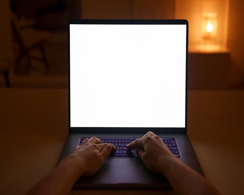 A person adjusting the distance of their laptop screen